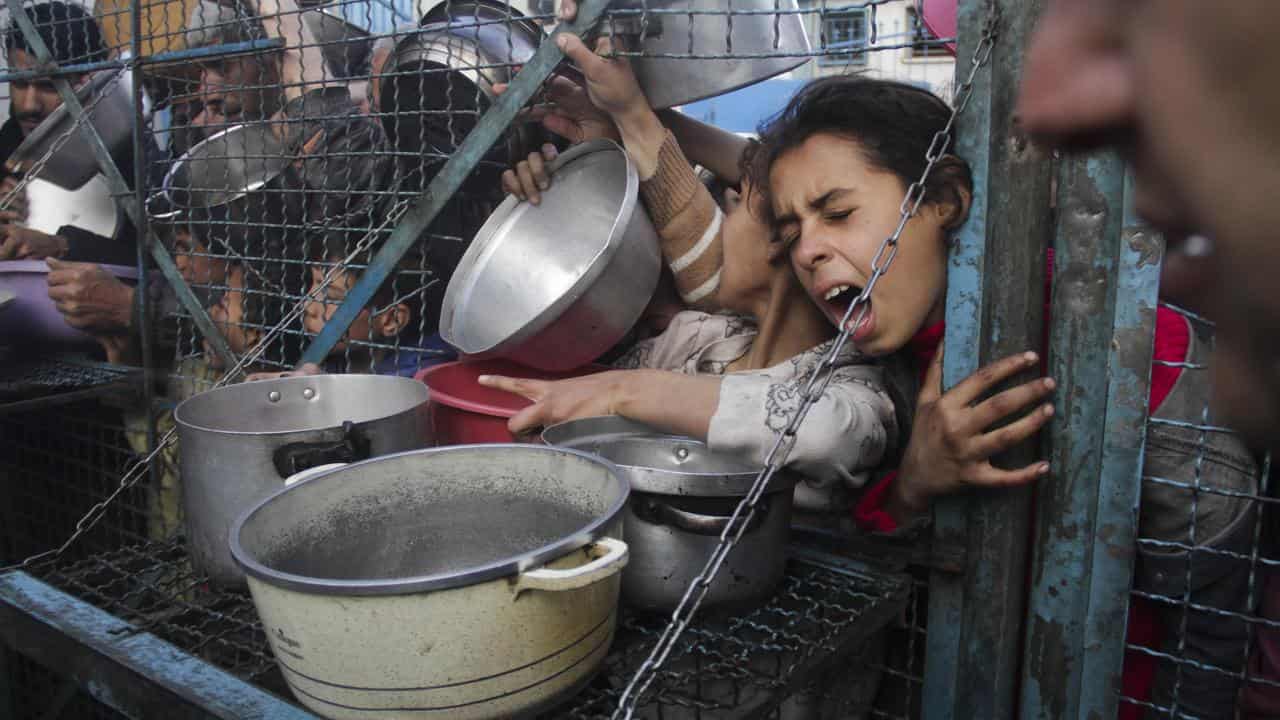 Palestinians line up at Jabaliya refugee camp in the Gaza Strip