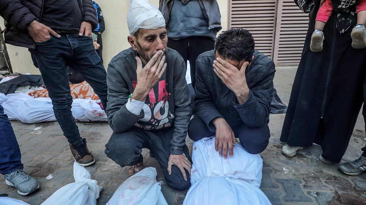 Palestinian relatives mourn the dead following an Israeli air strike