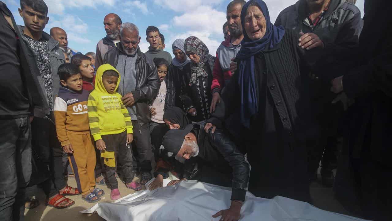 Palestinians mourn over their relatives' bodies in the Gaza Strip