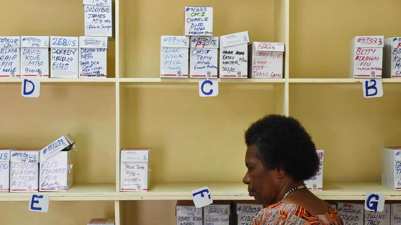 A community health worker dispenses medicine at a TB clinic in PNG.