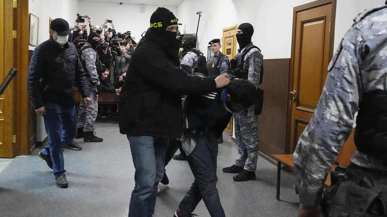 An FSB officer escorts Dalerdzhon Mirzoyev in Basmanny District Court