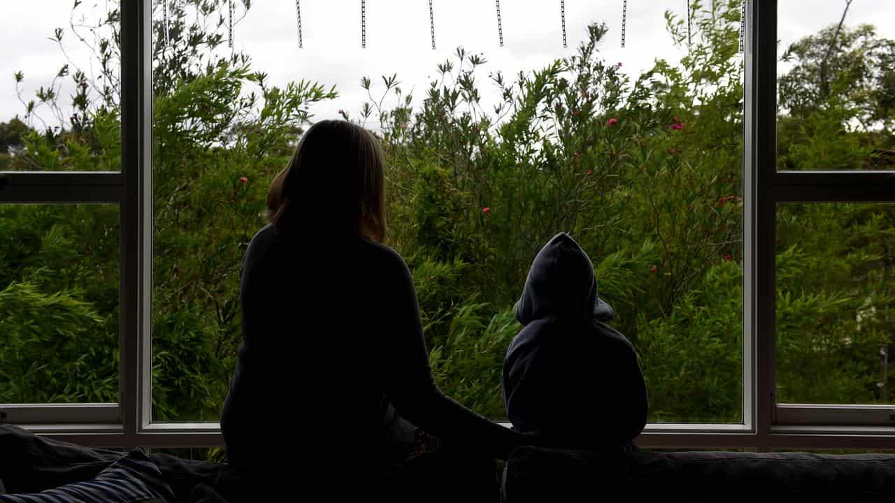 A woman and a child silhouetted against a window.