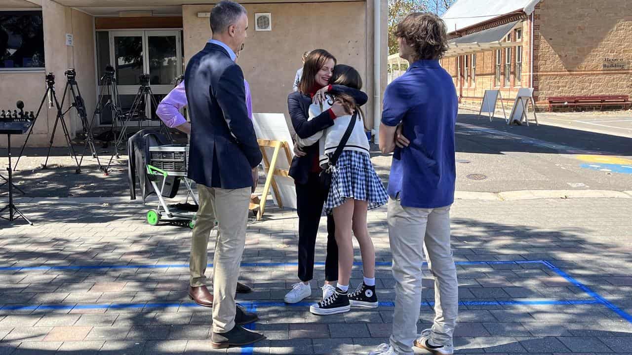 Cressida O’Hanlon hugs her family before voting.