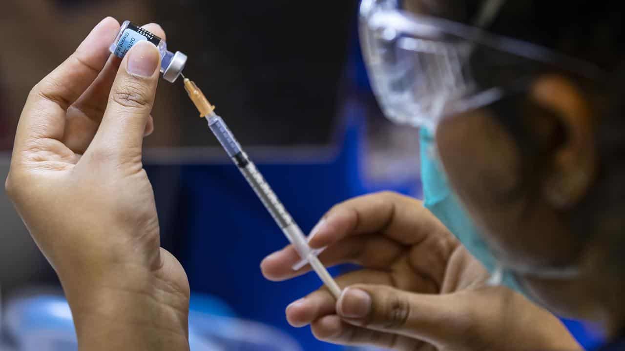 A healthcare worker prepares a Pfizer vaccine (file image)