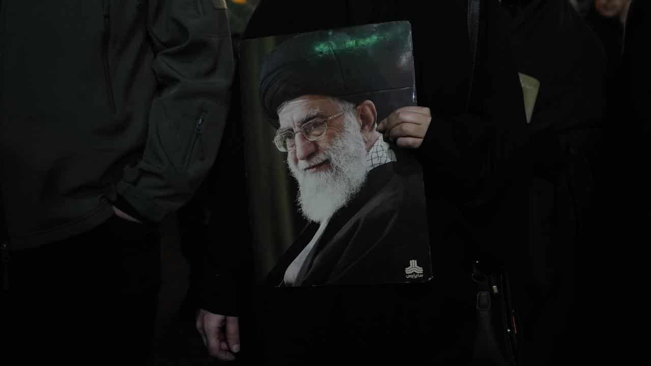 Protester holds a poster of the Supreme Leader Ayatollah Ali Khamenei