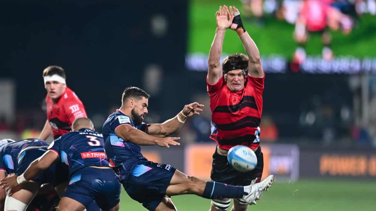 Ryan Louwrens kicks under pressure from Crusaders' Scott Barrett