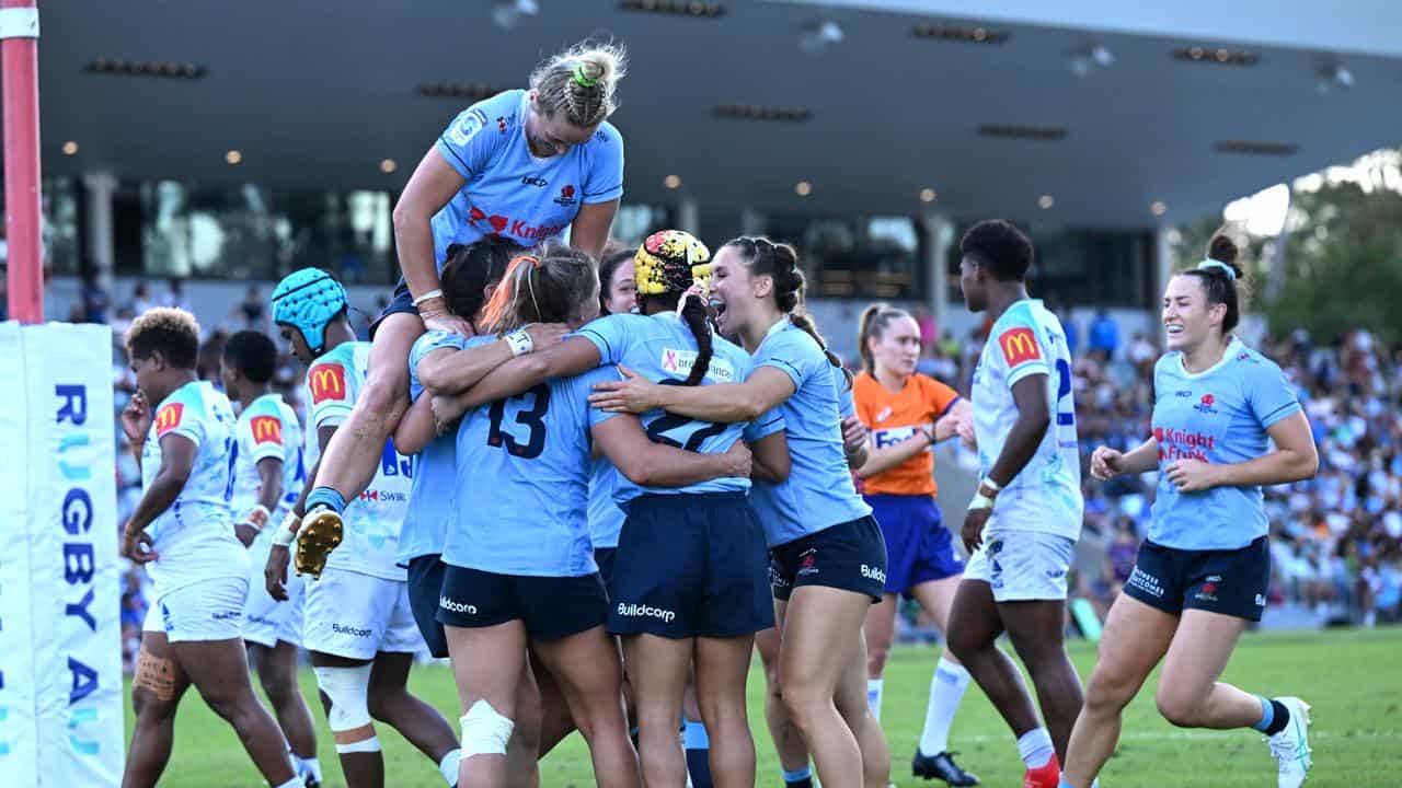 Waratahs players rush in to congratulate Georgina Friedrichs.