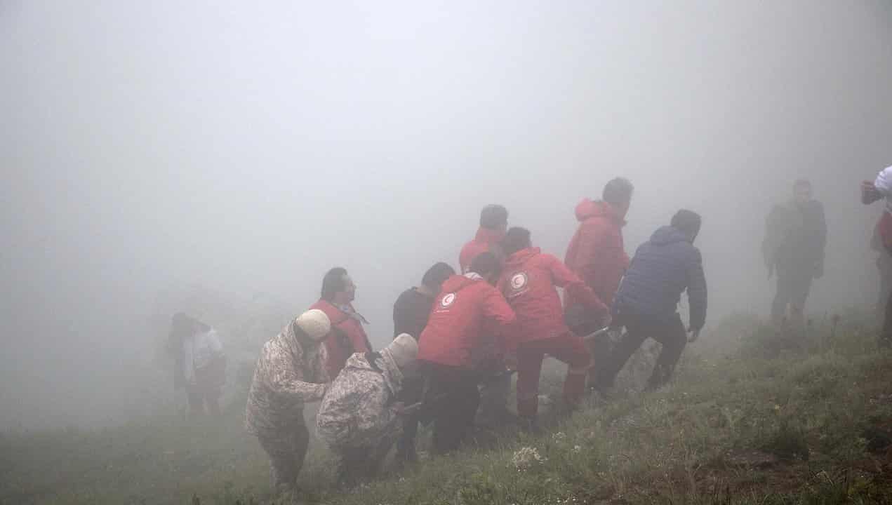 Rescuers carry the body of a victim of the helicopter crash in Iran