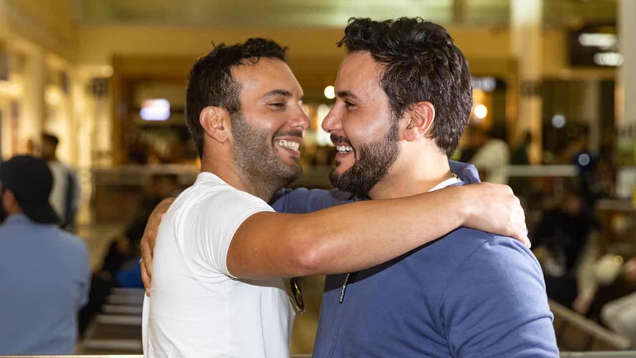 Traveller Fadi Chemali (left) arrives from New Caledonia 