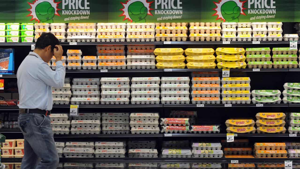 A shopper inspects eggs inside a Woolworths