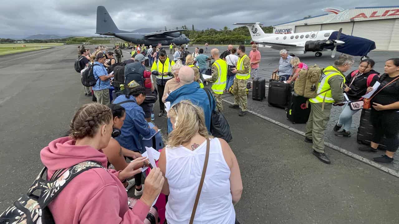 Tourists line up in Noumea to board a plane home