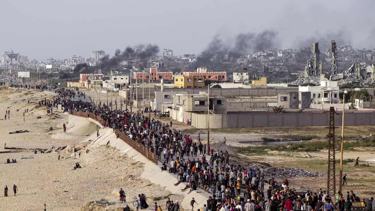 Palestinians await aid trucks in the central Gaza Strip