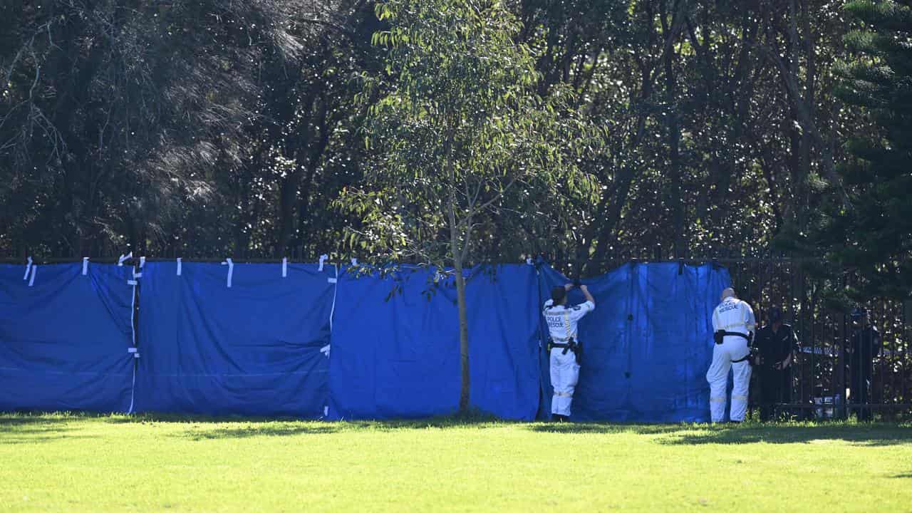 A NSW Police cordon off the scene on the banks of the Cooks River