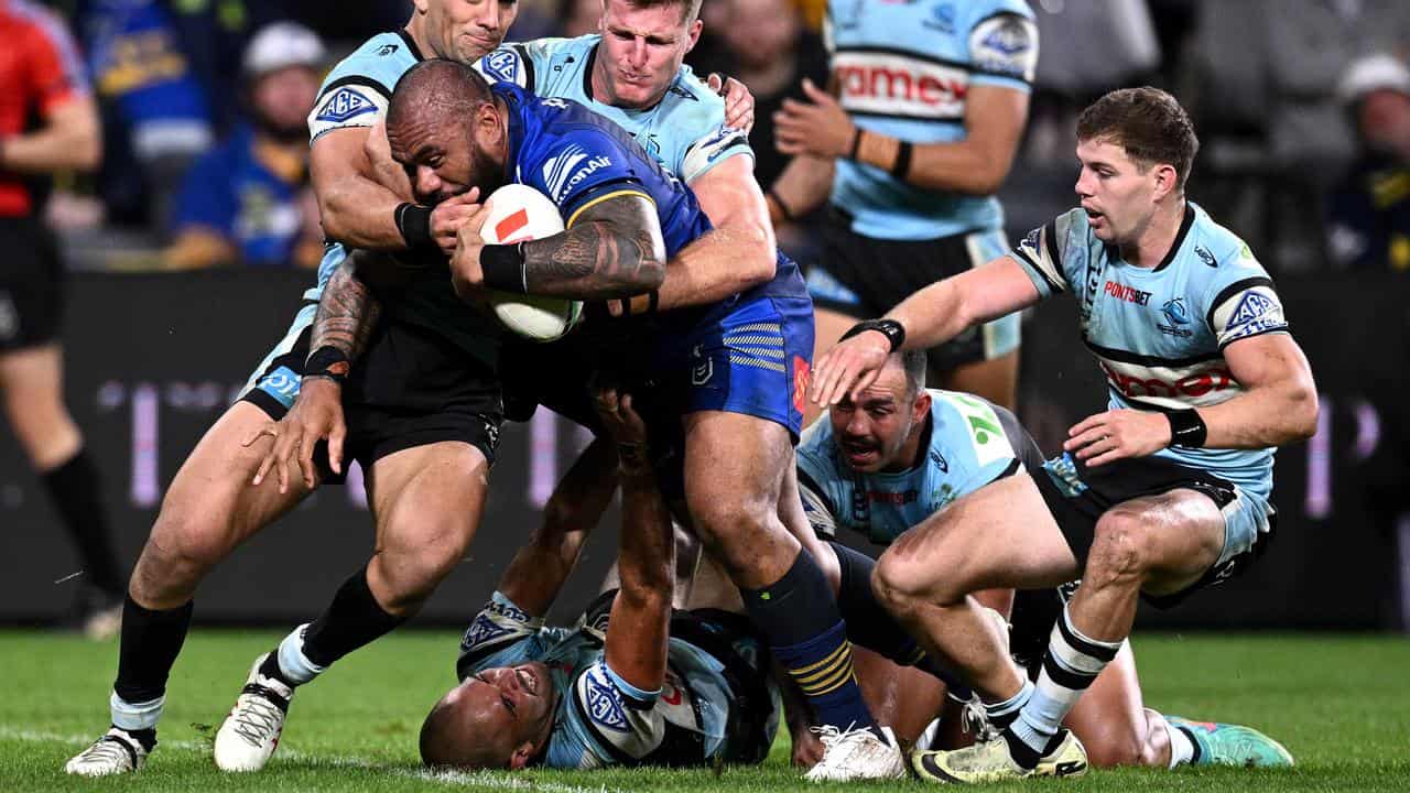 Junior Paulo of the Eels pushes through Sharks to score a try.