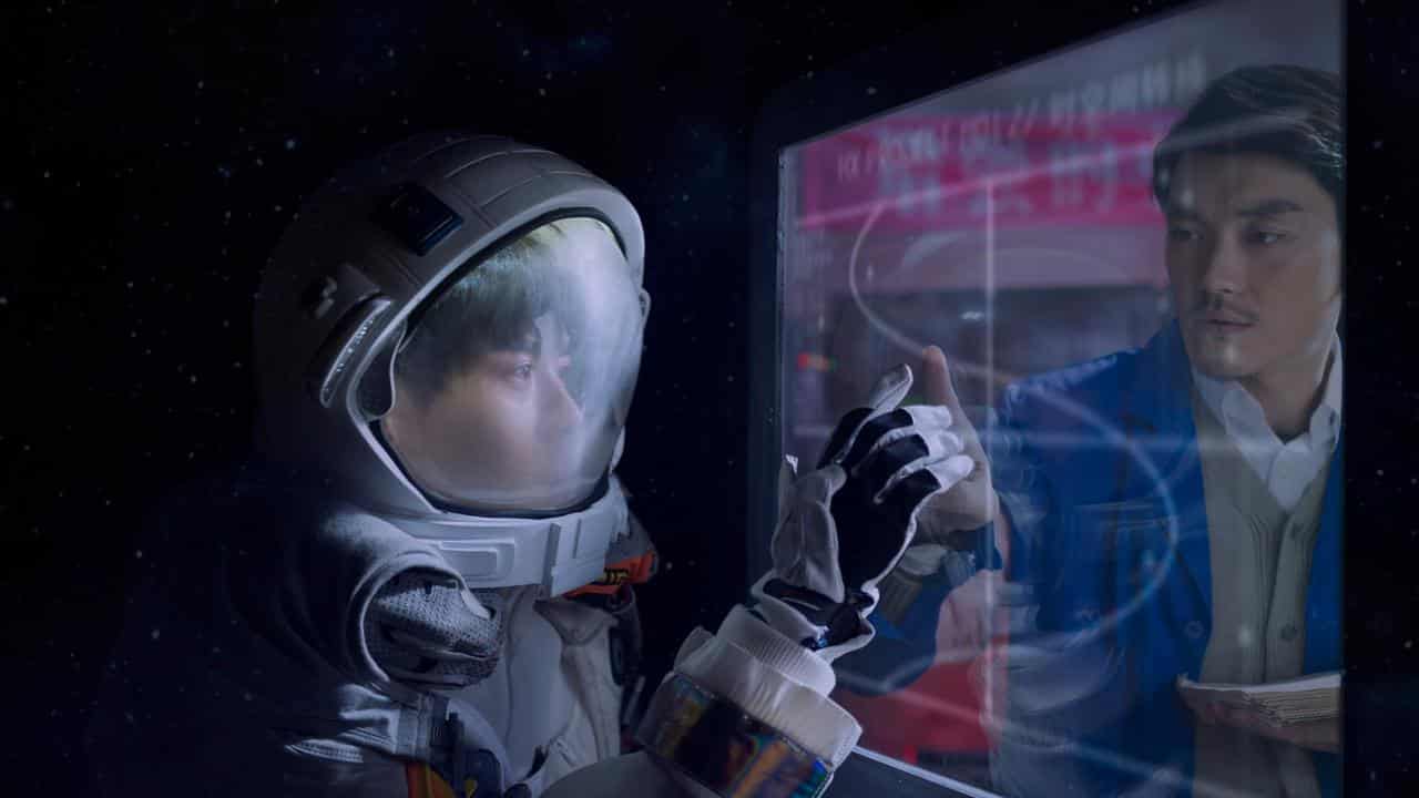 A person in a spacesuit touching a screen.