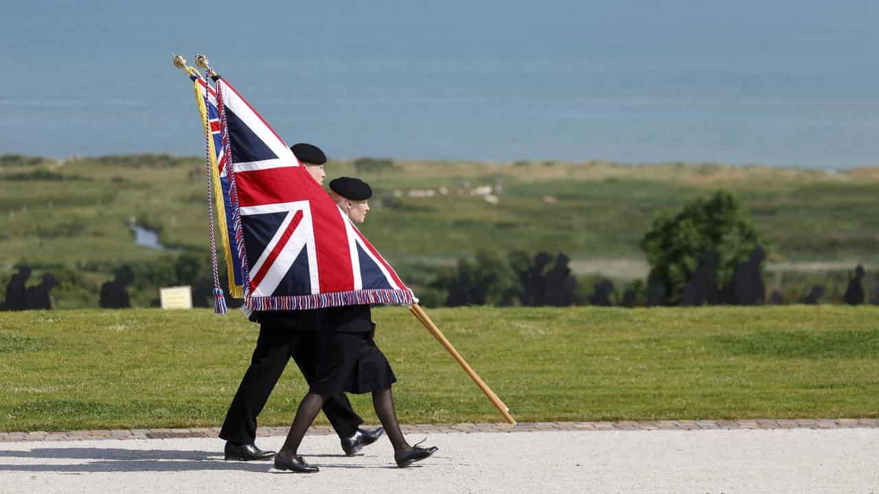 Youth carry the Union Flag at a D-Day commemoration in Normandy