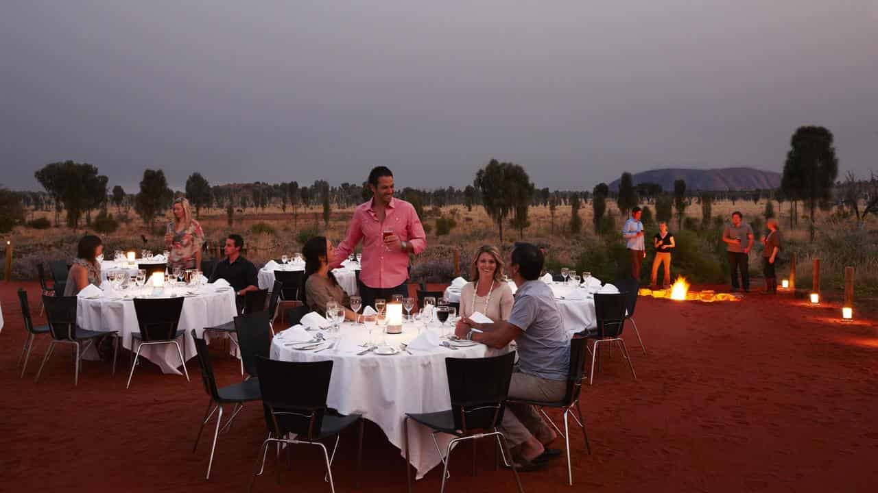 Tourists enjoy the evening near Uluru.