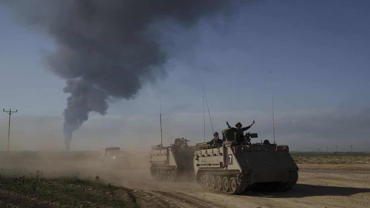 Israeli soldiers move on armoured personnel carriers in Gaza