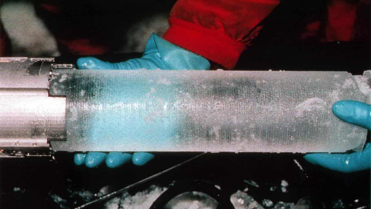 Two hands holding an ice core sample.