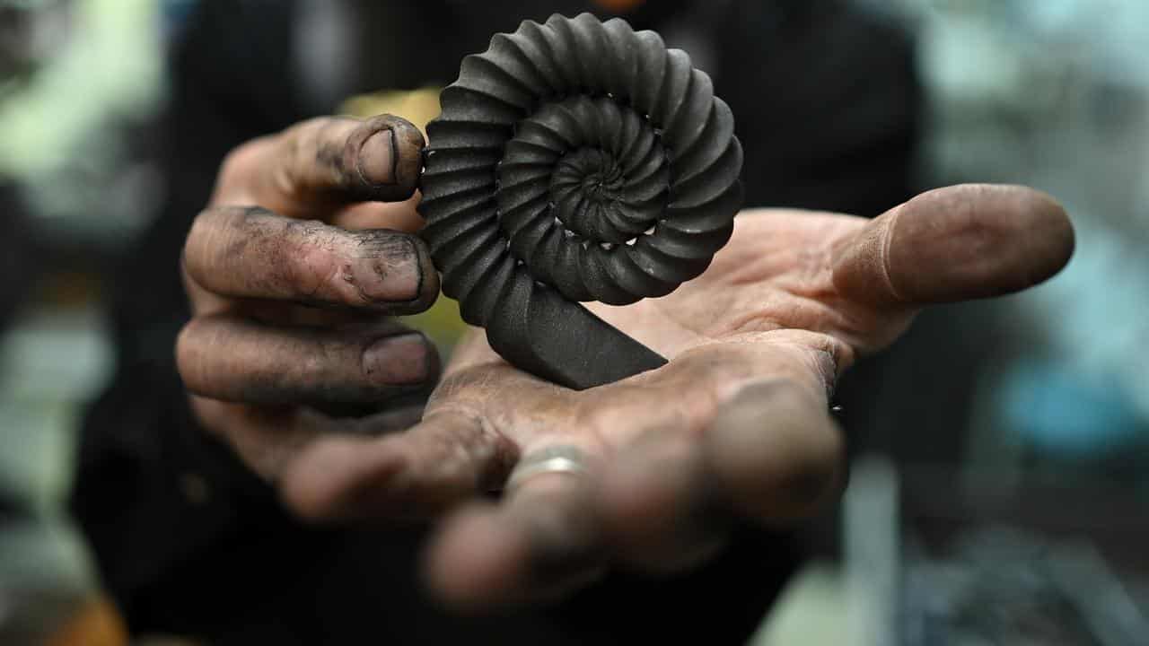 Steve Phillips holds up a project at Waterside Metal Art workshop