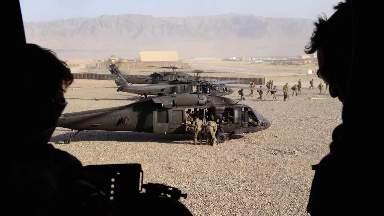 Soldiers get into a helicopter.