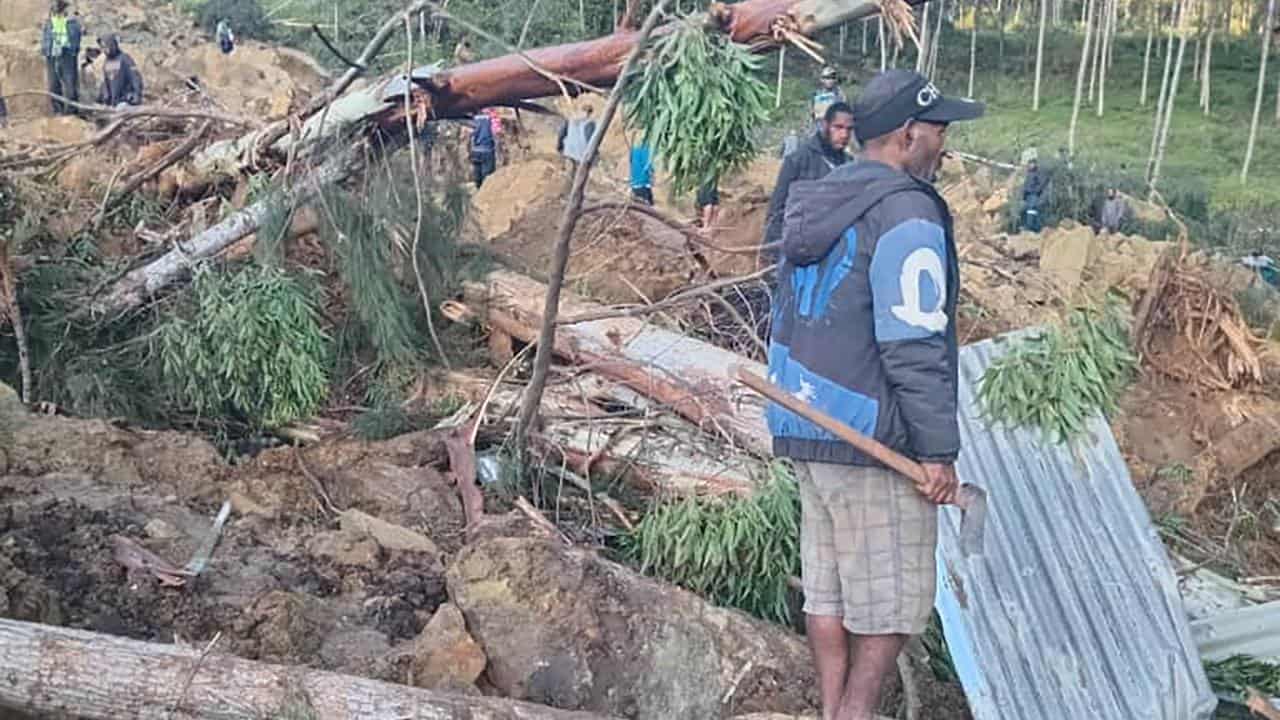 People work at the scene of the PNG landslide.