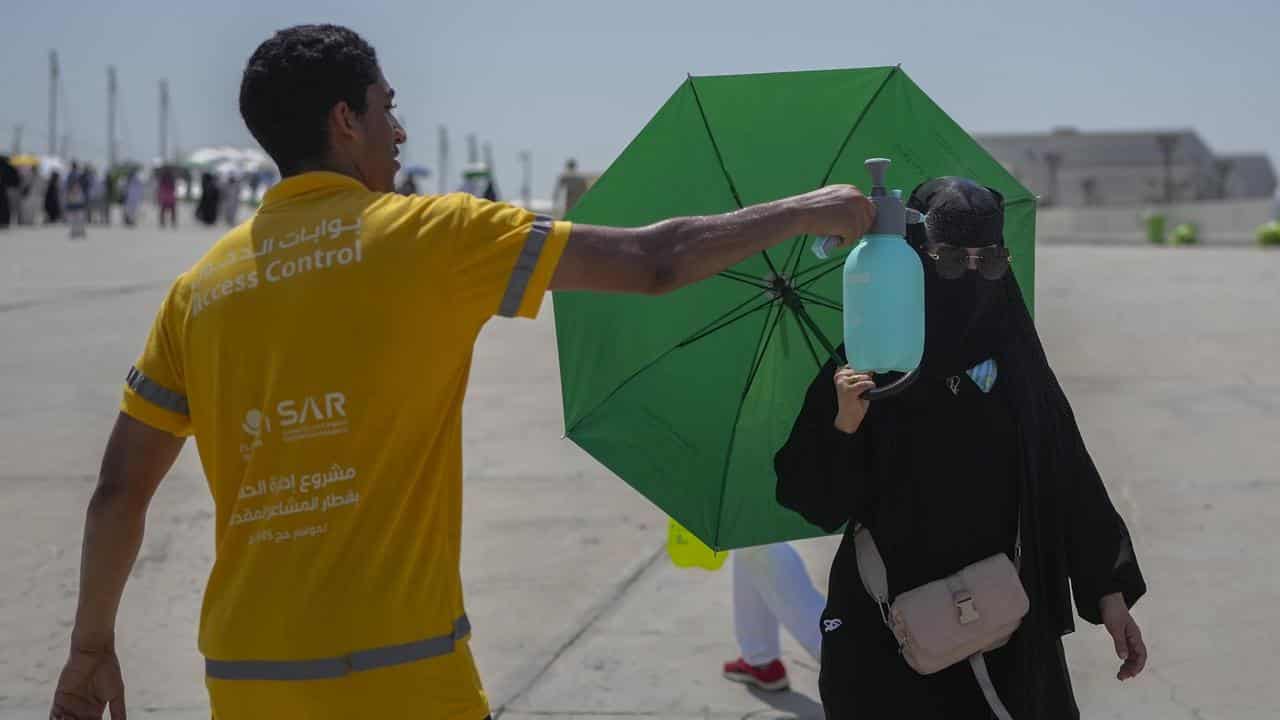 A pilgrim gets a cold water spray at the Hajj in Saudi Arabia.