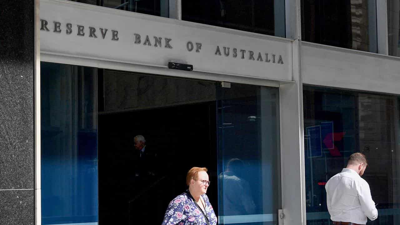 Pedestrians walk past the Reserve Bank of Australia