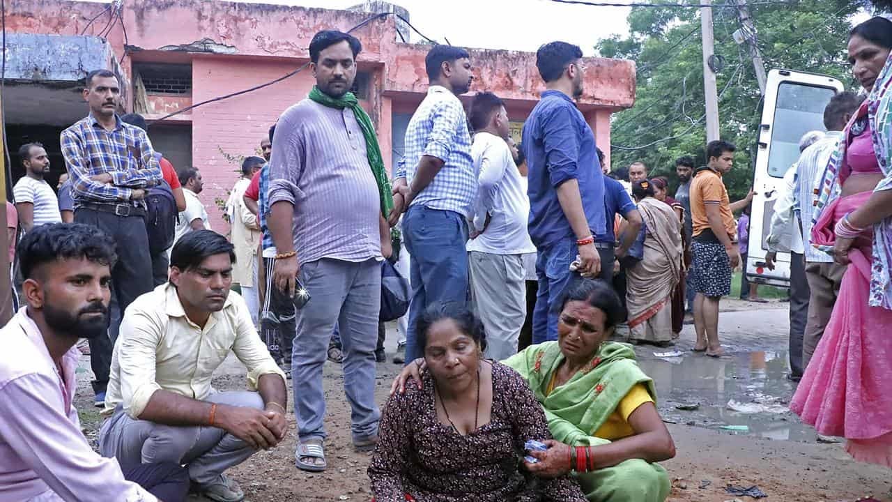 Women mourn next to the body of a relative