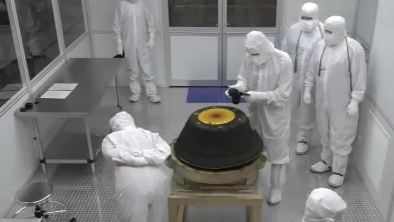 NASA technicians in a clean room examine the sample return capsule.