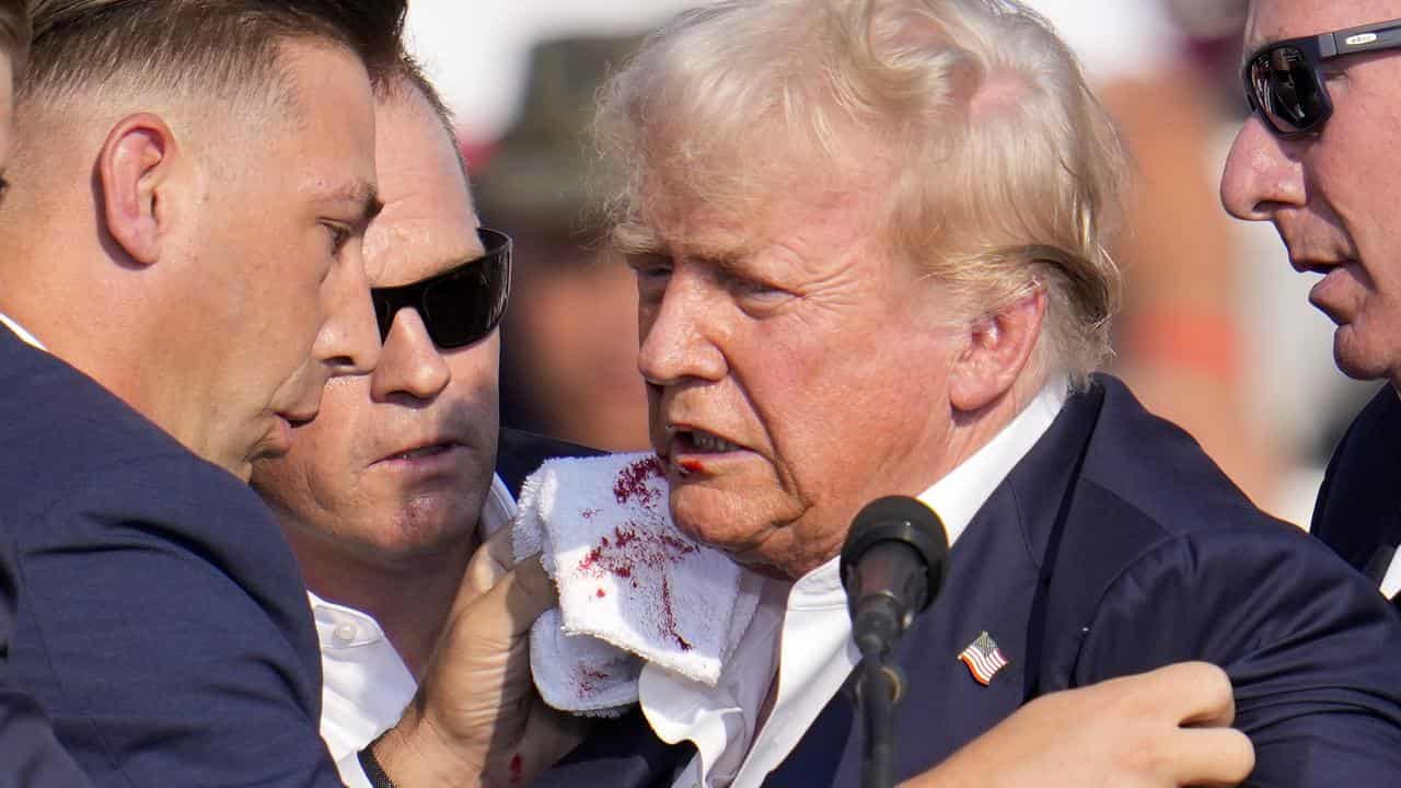 Secret Service staff attend to Donald Trump's wound after the shooting