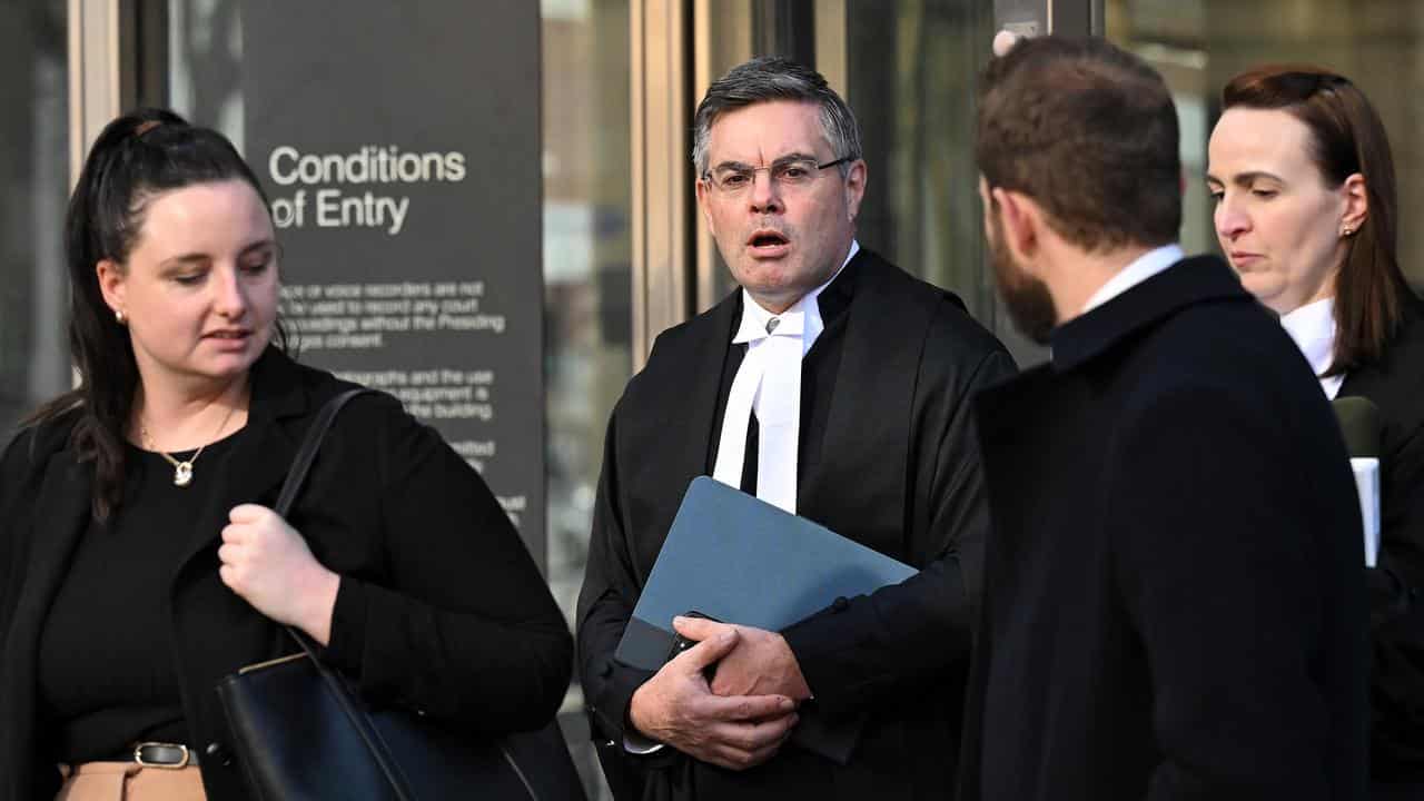 Prosecutor Darren Renton SC (2nd left) departs from the County Court