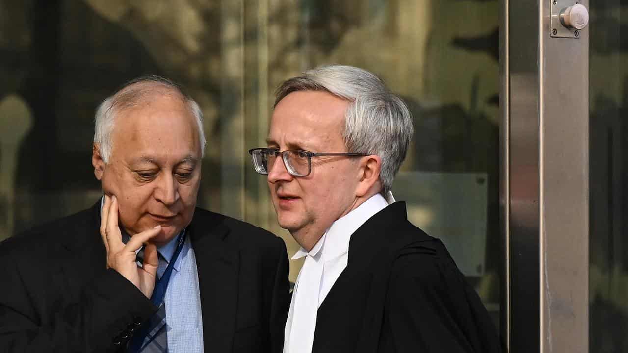 Defence barrister Andrew Buckland (right) departs the County Court