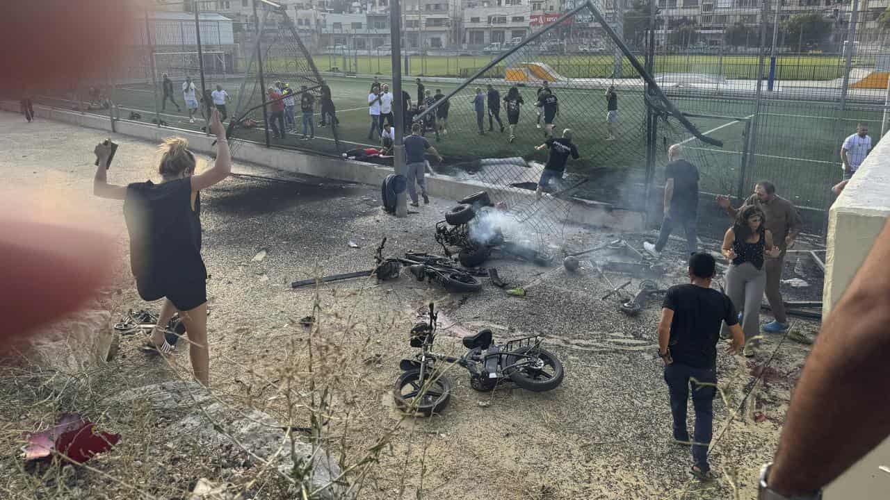 People run to the scene of a rocket attack.