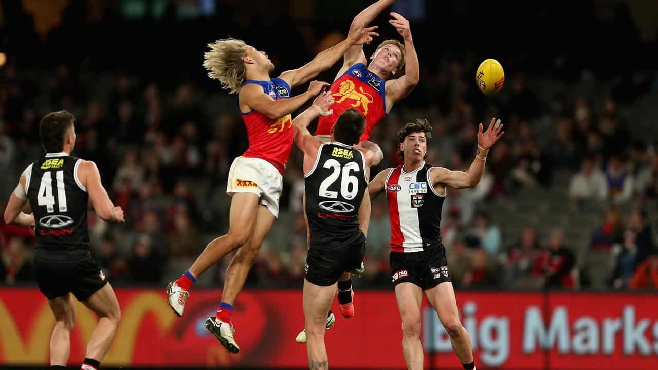 Kai Lohmann and Logan Morris leap high for the ball.