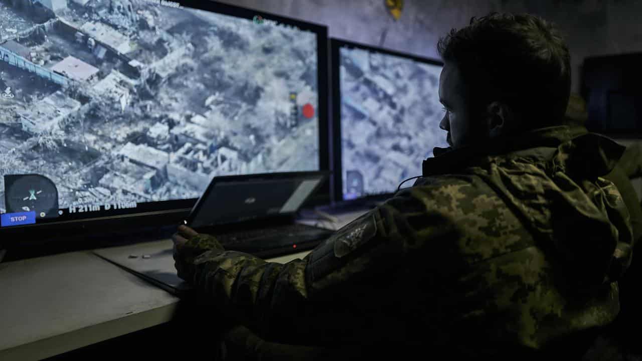 A Ukrainian soldier watches a drone feed from an underground bunker