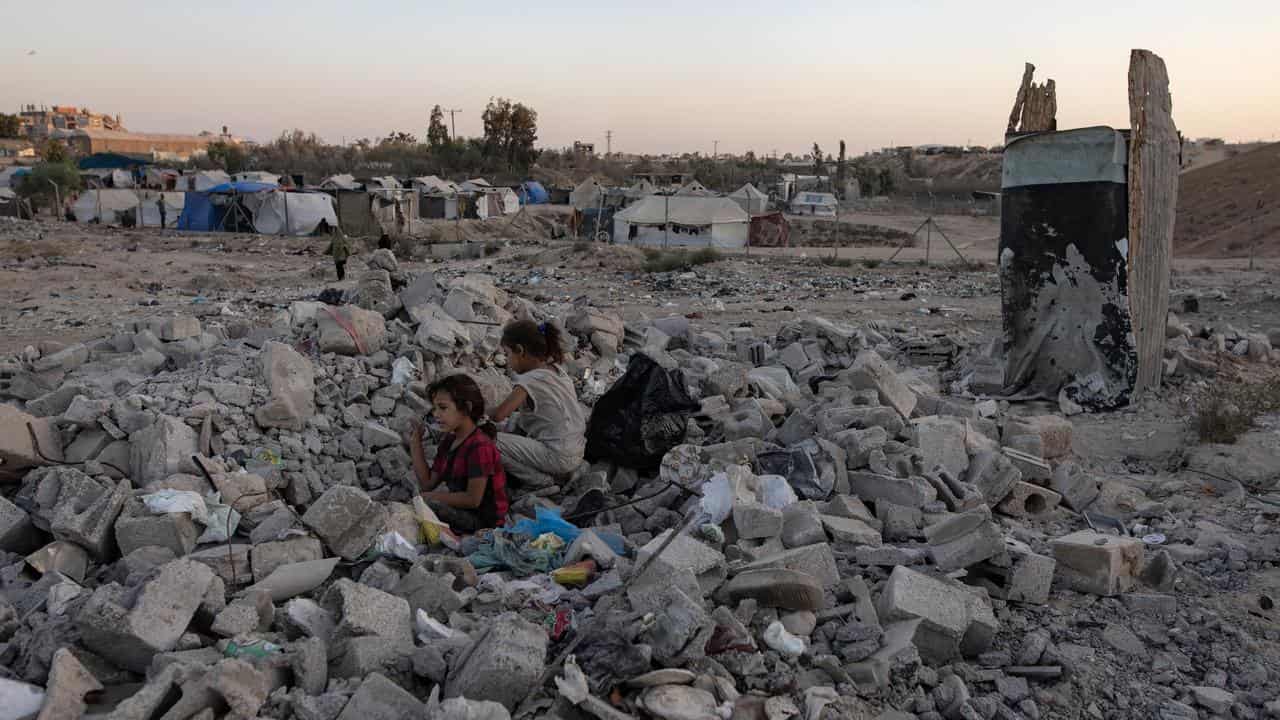 Children sitting in rubble