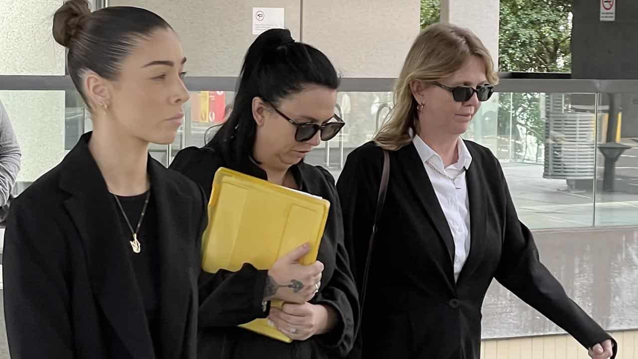 Emma Donald (centre, with yellow folder) leaves the inquest