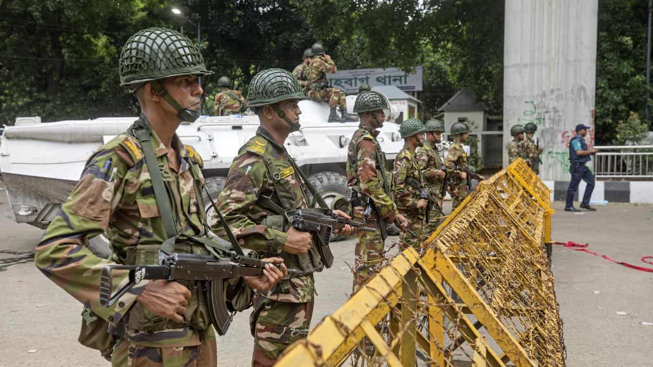 Soldiers stand guard behind a barrier during a curfew in Bangladesh