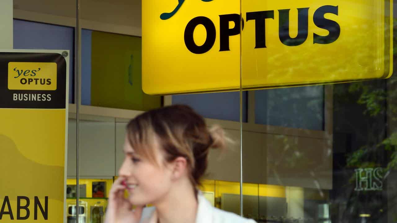 A woman talks on her mobile phone near an Optus shop