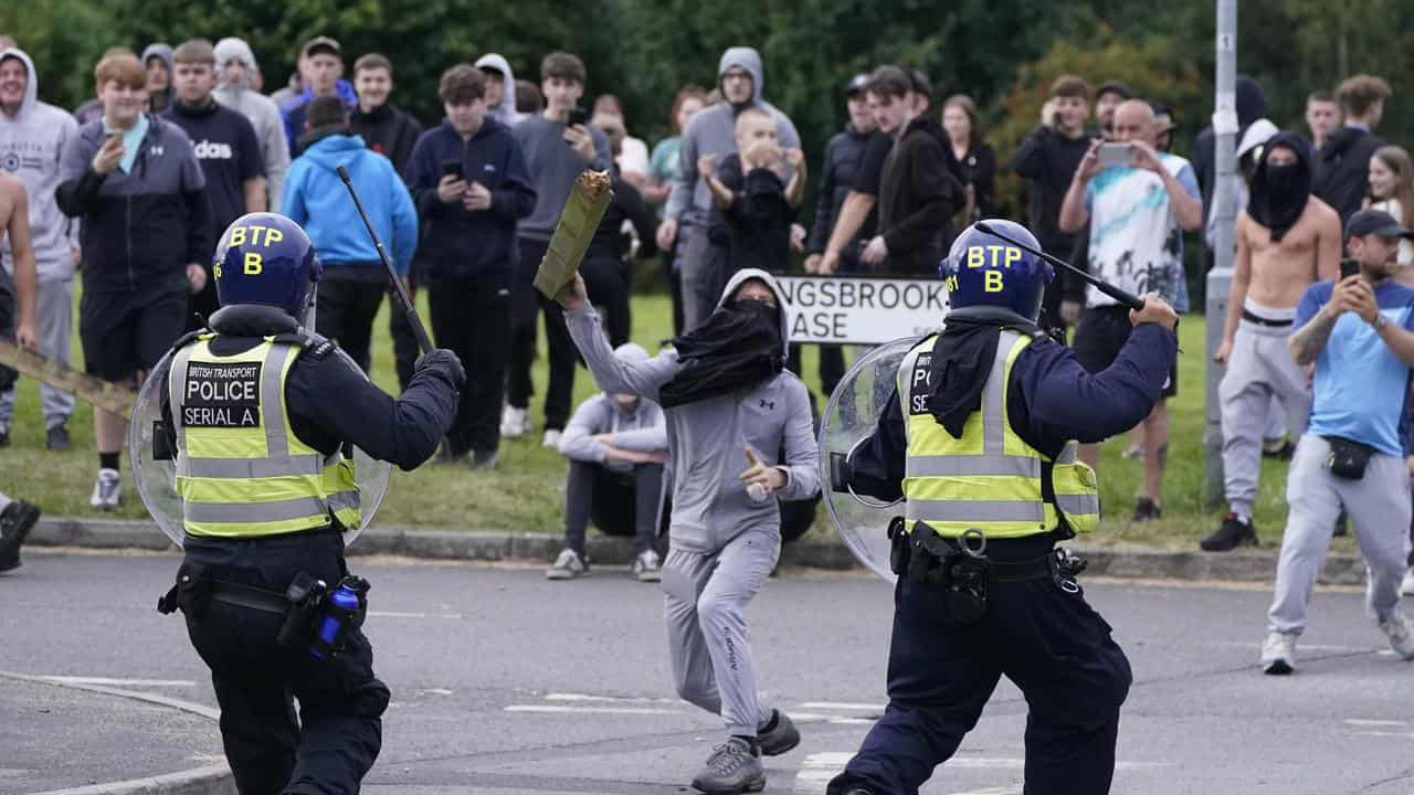 A youth throws a fence post towards police in Rotherham