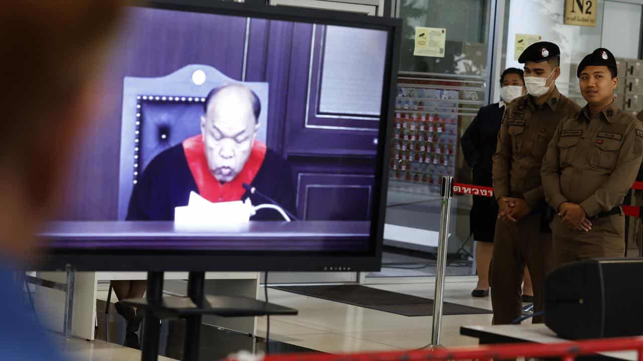 A TV screen shows Thai Constitutional Court judge reading the verdict 