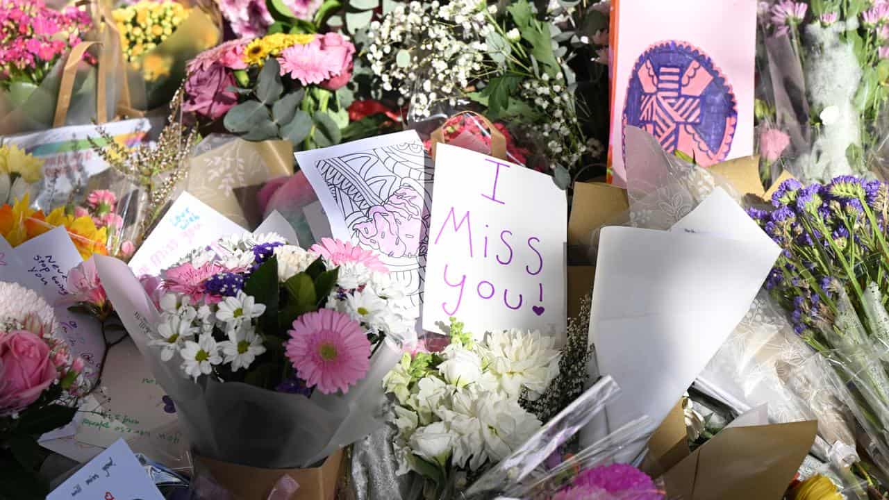 Cards and placed flowers at a memorial at her school.