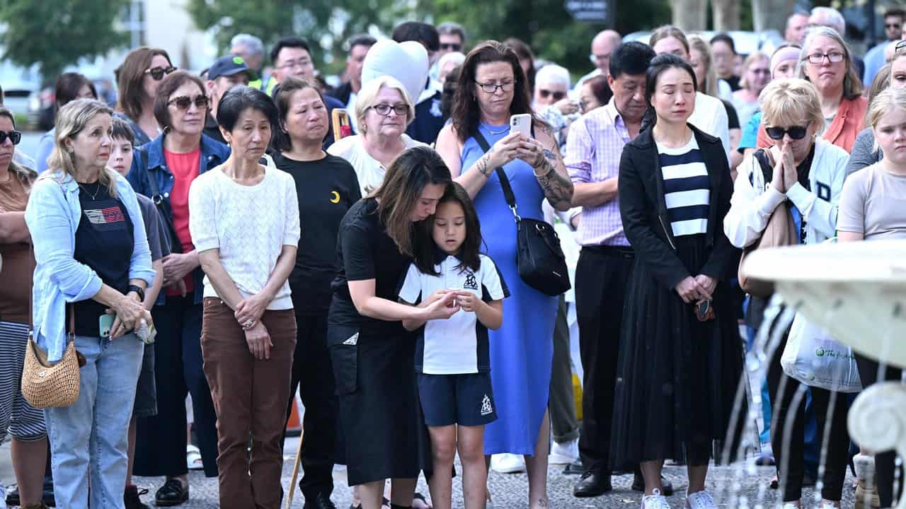 People lit candles around a fountain at the vigil.