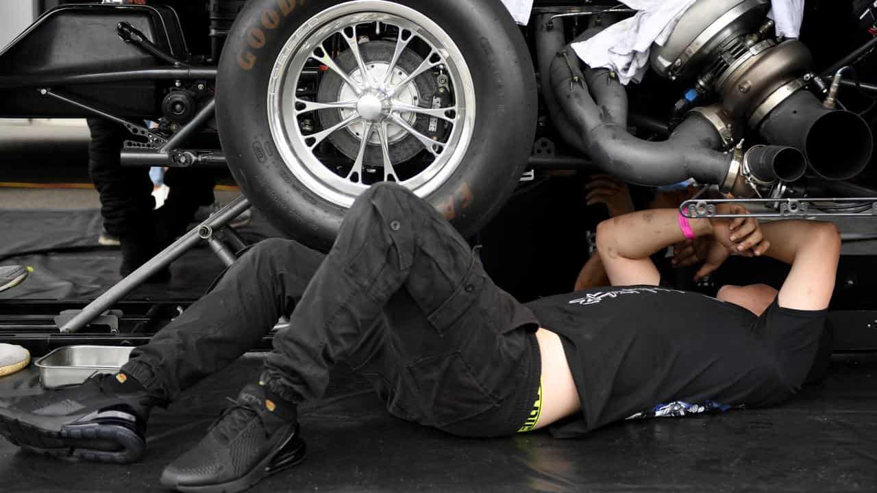 A mechanic works on a car.