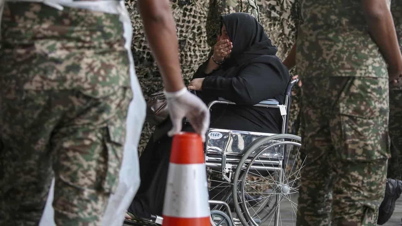 Malaysian army officers push a palestinian wheelchair patient 