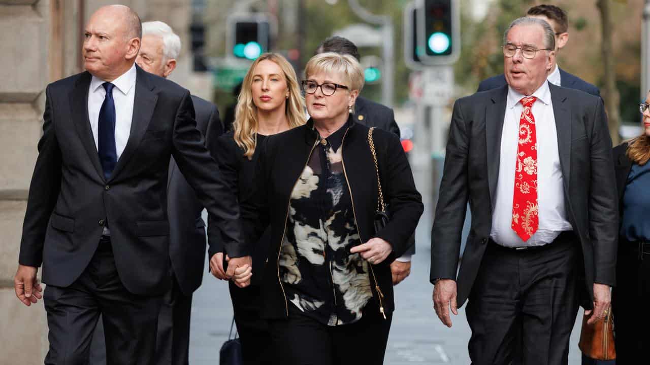 Senator Linda Reynolds walks with her husband and lawyer.