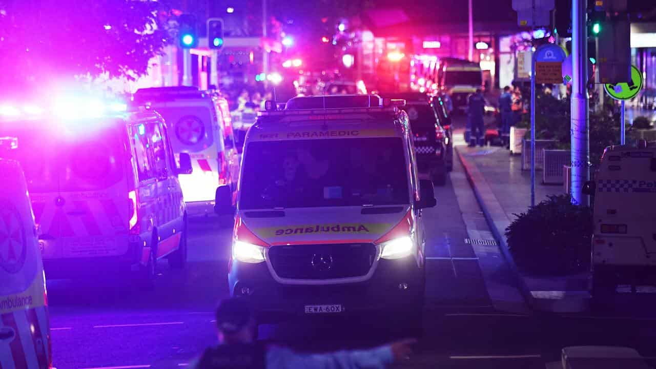 A police officer directs an ambulance