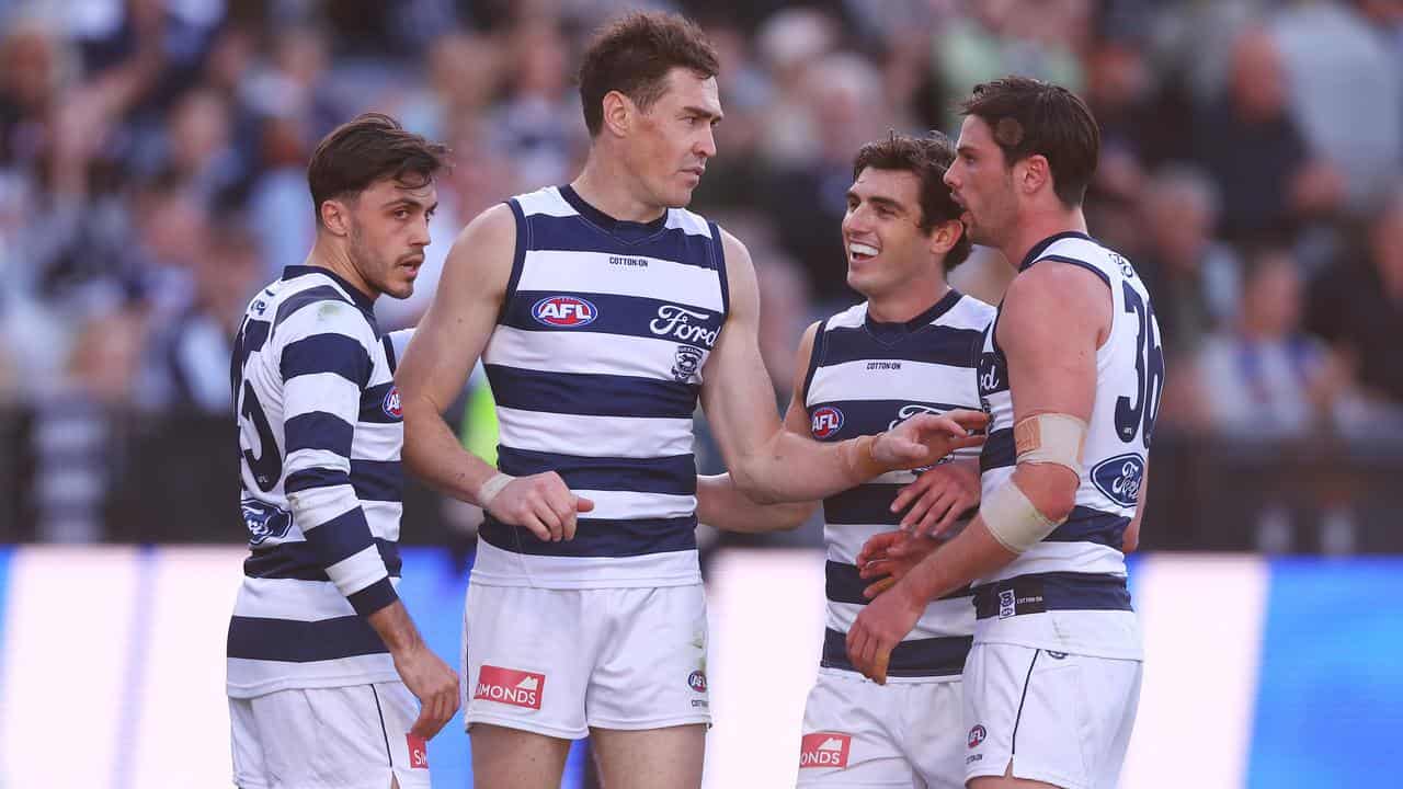 Geelong players celebrate a goal against West Coast.