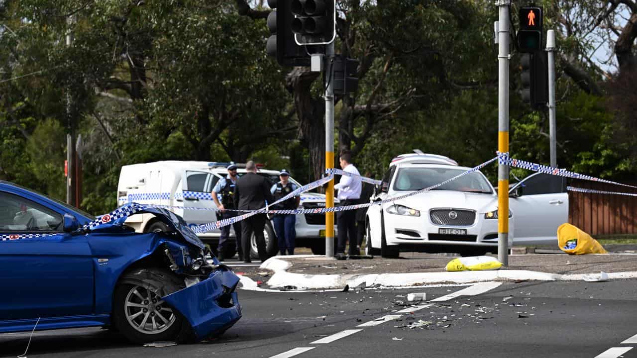 Two cars sit damaged on a street.